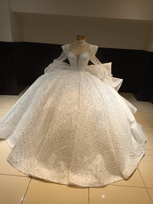 Crystal beaded ball gown wedding dress with cascading ruffle train and intricate detailing.
